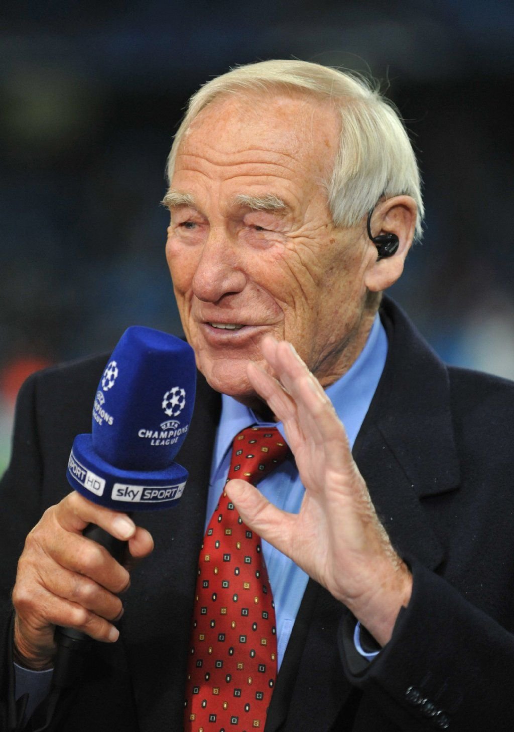 Bert Trautmann, ehemaliger deutscher Torhüter von Manchester City spricht in ein Mikrofon.
