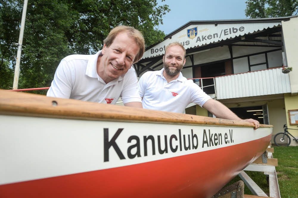 Bootsbauer Dirk Maibuhr und Marcel Beelitz (hinten) präsentieren stolz das Boot „Stadt Aken“, das mit eigenen Mitteln finanziert wurde.