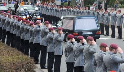 Die Särge der drei in Afghanistan gefallenen Soldaten werden nach der Trauerfeier in der St. Lamberti-Kirche im niedersächsischen Selsingen (Kreis Rotenburg-Wümme) durch ein Spalier von salutierenden Soldaten gefahren. (FOTO: DPA)