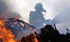 Ein Feuerwehrmann löscht bei einem Großbrand in einer Lagerhalle einer Müllaufbereitungsanlage in Döllnitz (Kreis Merseburg, Sachsen-Anhalt) am Mittwoch (24.05.2006). (Foto: dpa)