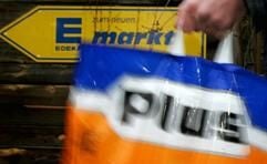 Ein Mann hält vor einem Edeka Markt in Dresden eine Einkaufsplastiktüte des Discounters Plus in der Hand. (Foto: ddp)