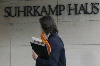 Eine Frau geht in Frankfurt/Main vor einem Schriftzug des Suhrkamp Hauses. (FOTO: DDP)