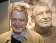 Der Dichter Ulf Stolterfoht steht in Staufen im Breisgau vor einer Fotografie des Dichters Peter Huchel. (Foto: dpa)
