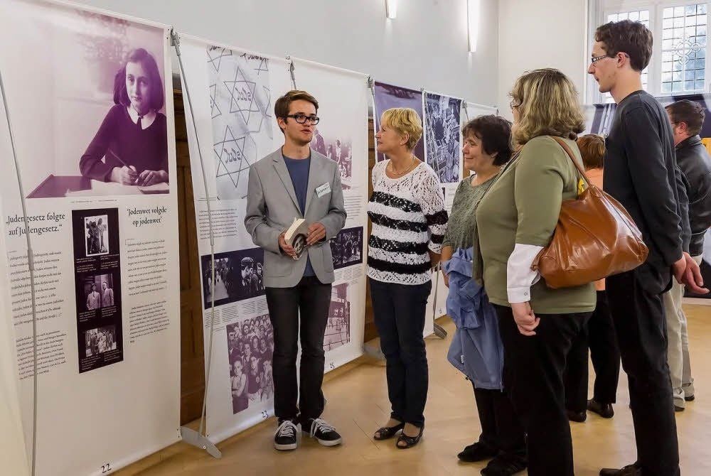 Schüler Johannes Gerber erklärt den Besuchern die Ausstellung.