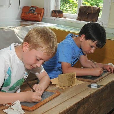 Die alten Schulsachen locken auch heutige Schüler wie Hannes und Lukas (v.li.) zum Ausprobieren.