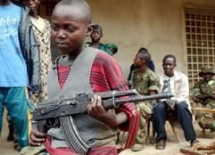 Ein zwölfjähriger Kongolese «partrouilliert» mit seiner Kalaschnikow-Maschinenpistole auf den Straßen der Stadt Bunia. (Foto: dpa)