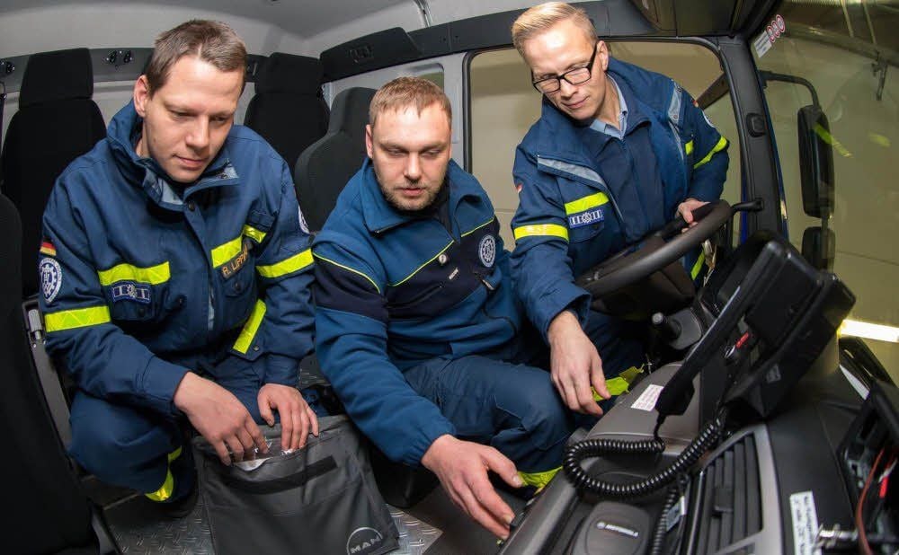 THW-Mitglieder aus Aue-Schwarzenberg inspizieren ihr neues Fahrzeug bei der Übergabe in Elster