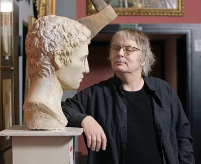 Der Chef des Dresdner Kabaretts «Herkuleskeule», Wolfgang Schaller, steht an einem Gipskopf, den eine Axt spaltet (FOTO: DPA)