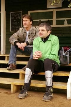 Zwei Rivalen unter sich: Pfarrer Goodfellow (Rowan Atkinson, r) ahnt nicht, dass Lance (Patrick Swayze, l) in dem Film «Mord im Pfarrhaus» ein doppeltes Spiel spielt (undatierte Filmszene). (Foto: dpa)