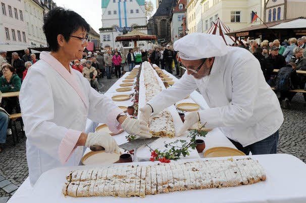 Spielleute führen den Tross auf den Markt. Karin und Hanspeter Corente schneiden die elf Meter lange Stolle auf.