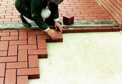 Nur für erfahrene Heimwerker zu schaffen: Wenn Platten oder Pflasterklinker als Terrassenbelag gewählt werden, erfordert bereits das Anlegen des Unterbaus ausreichend Fachkenntnisse. (Foto: dpa)