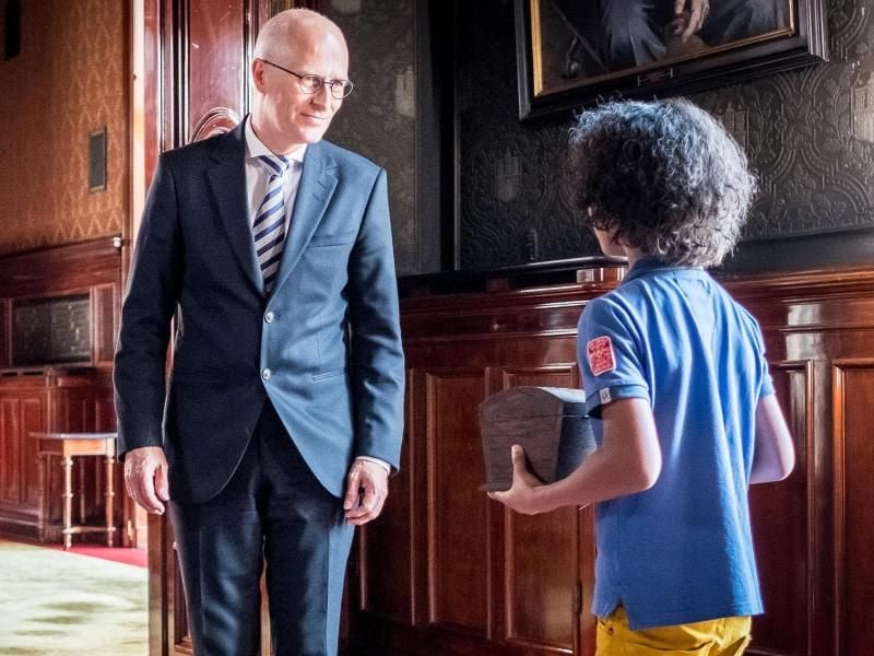 „Die Pfefferkörner” überreichen Hamburgs Bürgermeister Peter Tschentscher (SPD) den Schatz in einer Szene der 200. Folge der Serie. Foto: Boris Laewen/NDR/ARD/dpa