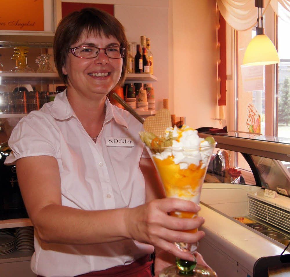 Sandra Ockler präsentiert im Backshop und Café Hoffmann in Jessen einen Pfirsicheisbecher.