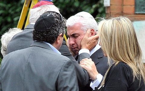 Der Vater der verstorbene britischen Sängerin Amy Winehouse, Mitch Winehouse (M.) wird von Freunden getröstet. (FOTO: DPA)