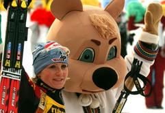 Die deutsche Biathletin Martina Glagow läuft am Sonntag (16.03.2003) nach dem 10 km-Verfolgungswettbewerbes der Damen im Rahmen der Biathlon-Weltmeisterschaft im sibirischen Chanty Mansijsk mit einer russischen Märchenfigur zur Siegespräsentation. Sie hatte das Rennen im Fotofinish gemeinsam mit der Französin Sandrine Bailly gewonnen. (Foto: dpa)