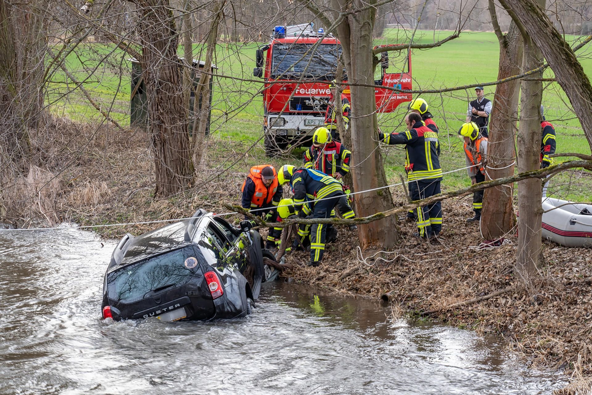 Die Feuerwehrleute bergen ein Auto mit einer Stahlseile aus der Ilm.