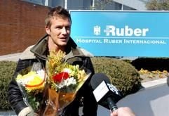 Blumen für Frau Victoria: Ehemann und Vater David Beckham bei seiner Ankunft vor dem Ruber-Krankenhaus in Madrid. (Foto: dpa)