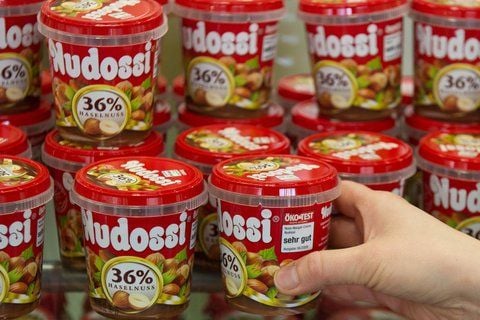 Eine Mitarbeiterin sortiert in Berlin am Alexanderplatz im Laden «Ostpaket» Becher mit dem Brotaufstrich «Nudossi» ins Regal. (FOTO: DPA)