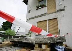 Mit einem rot-weißen Band ist die Unfallstelle am Freitagmorgen (29.07.2005) in Brühl (Rhein-Neckar-Kreis) abgesperrt. Beim Absturz eines Balkons sind hier am Vorabend drei Menschen getötet und zwei schwer verletzt worden. (Foto: dpa)