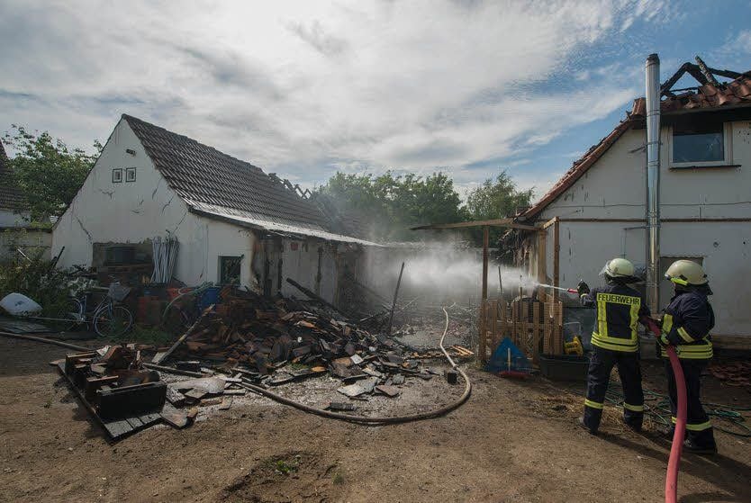 Die Feuerwehr bei Restlöscharbeiten auf dem Grundstück.