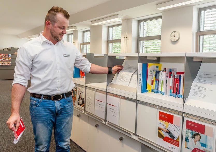 Frederic Schulze zeigt eine der vier „Themeninseln“ im neuen Berufsinformationszentrum in Wittenberg.