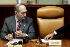 Der israelische Premierminister Ehud Olmert schaut auf den leeren Stuhl neben ihm, auf dem normalerweise Ariel Scharon sitzt. (Foto: dpa)