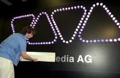 Mitarbeiter des Fernsehsenders "Viva " bringen den Schriftzug "Viva Media AG" an der Wand des Standes von Viva auf der Musikmesse "Popkomm" in Koeln an. Der Koelner Medienkonzern rechnet für das Gesamtjahr mit roten Zahlen bei einem Umsatz auf Vorjahresniveau. (Foto: dpa)