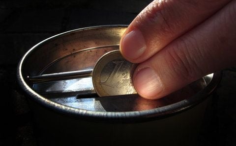 Eine Ein-Euro-Münze wird in eine Geldsammelbüchse gesteckt. (SYMBOLFOTO: DPA)