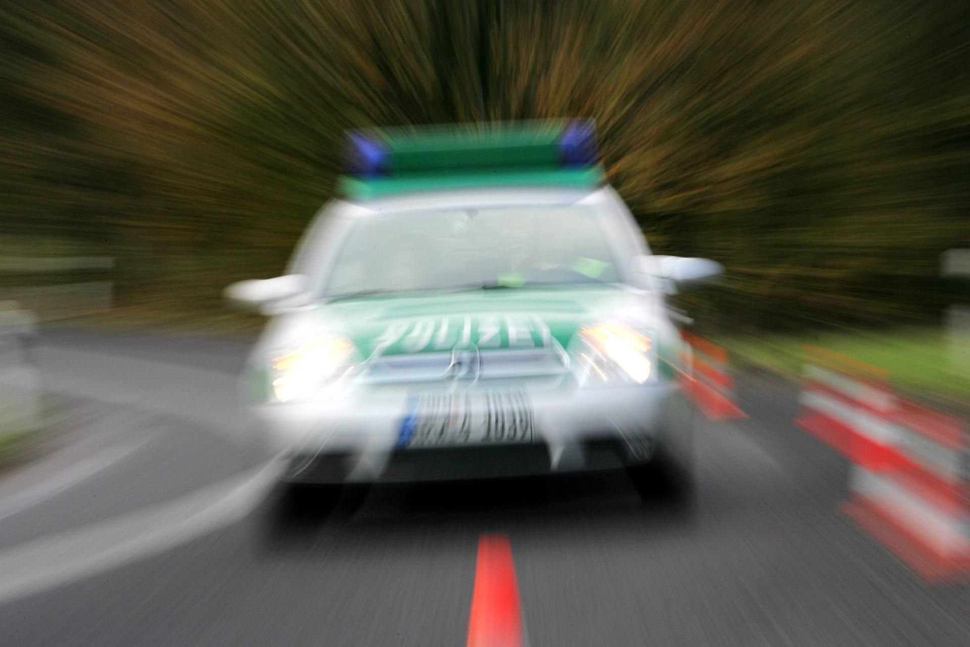 Ein Streifenwagen ist auf einer Straße unterwegs.