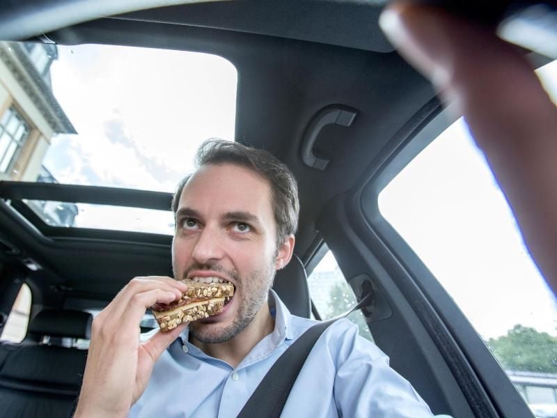 In die herzhafte Stulle beißt man als Fahrer lieber nur, während das Auto steht. Foto: Christin Klose/dpa-tmn