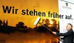 Wolfgang Böhmer (CDU), bis 20. März 2011 Ministerpräsident von Sachsen-Anhalt, klebt im Mai 2005 in Magdeburg zum Beginn der bundesweiten Werbekampagne ein Plakat mit dem Schriftzug: «Wir stehen früher auf».