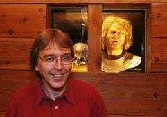 Der Hamburger Archäologe Ralf Wiechmann sitzt im Museum für Hamburgische Geschichte in Hamburg vor dem angeblichen Schädel des Freibeuters Klaus Störtebeker und der Nachbildung Störtebekers. (Foto: dpa)