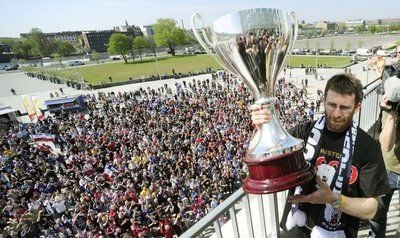 Der Spieler der Berliner Eisbären, Sven Felski, präsentiert am Donnerstag in Berlin den Meisterschaftspokal der Eishockey-Bundesliga den feiernden Fans. (FOTO: DPA)