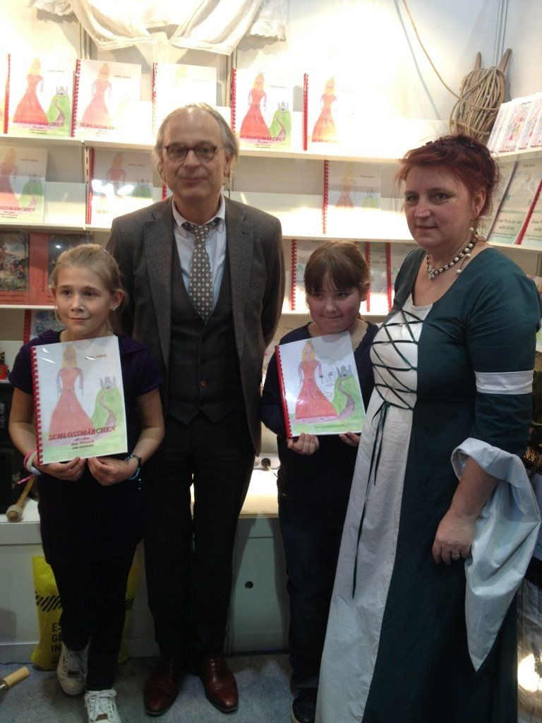 Mädchen auf der Messe: v.l. Jennifer Handt, Kultusstaatssekretär Jan Hoffmann, Annabell Joy Tietz und Ilonka Struve vom Museum Schloss Neu-Augustusburg Weißenfels.
