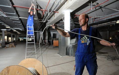 Elektriker Matthias Bahn und Frank Gerlach verlegen Kabel für die neue Deckenbeleuchtung im Erdgeschoss des Kaufhauses. (FOTO: ENGELBERT PÜLICHER)