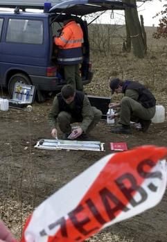 Kriminaltechniker sichern am Montag (10.03.2003) auf einem Feldweg in der Nähe von Dolle bei Stendal Spuren. Mehrere bewaffnete und maskierte Räuber haben am Montagvormittag in Dolle (Sachsen-Anhalt) einen Geldtransporter überfallen. Die Unbekannten haben mit Maschinenpistolen auf den Wagen gefeuert und dabei einen Wachmann verletzt, sagte ein Polizeisprecher in Stendal. Nach dem Überfall, der sich gegen 8.50 Uhr ereignete, flüchteten die Räuber mit ihrem Auto. In etwa drei Kilometern Entfernung vom Tatort wechselten sie das Fluchtfahrzeug. Den ersten Wagen ließen die Räuber ausbrennen, um Spuren zu verwischen. (Foto: dpa)