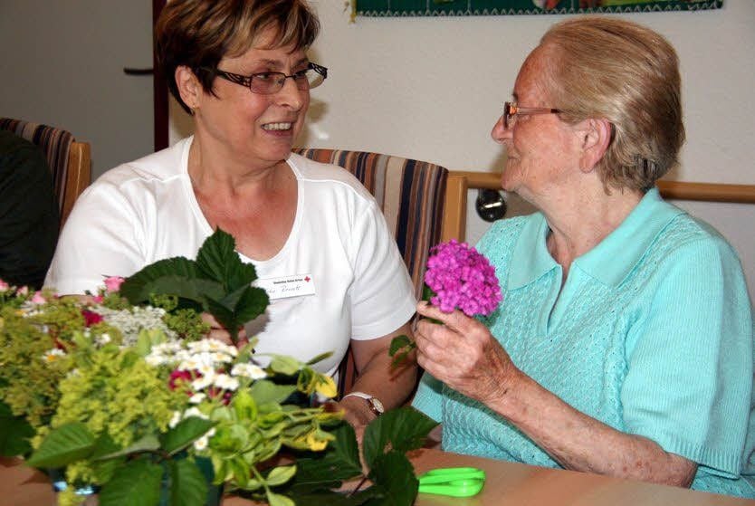 Schwester Renate verbreitet stets gute Laune. Hier fertigt sie mit Rosemarie Schiller Blumenschmuck für die Tische in der Tagespflege an.