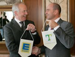 Karl-Erivan Haub (r.), Geschäftsführender Gesellschafter der Unternehmensgruppe Tengelmann, und Alfons Frenk, Vorstandvorsitzender der EDEKA AG überreichen sich in Mülheim die Firmenwimpel. (Foto: dpa)