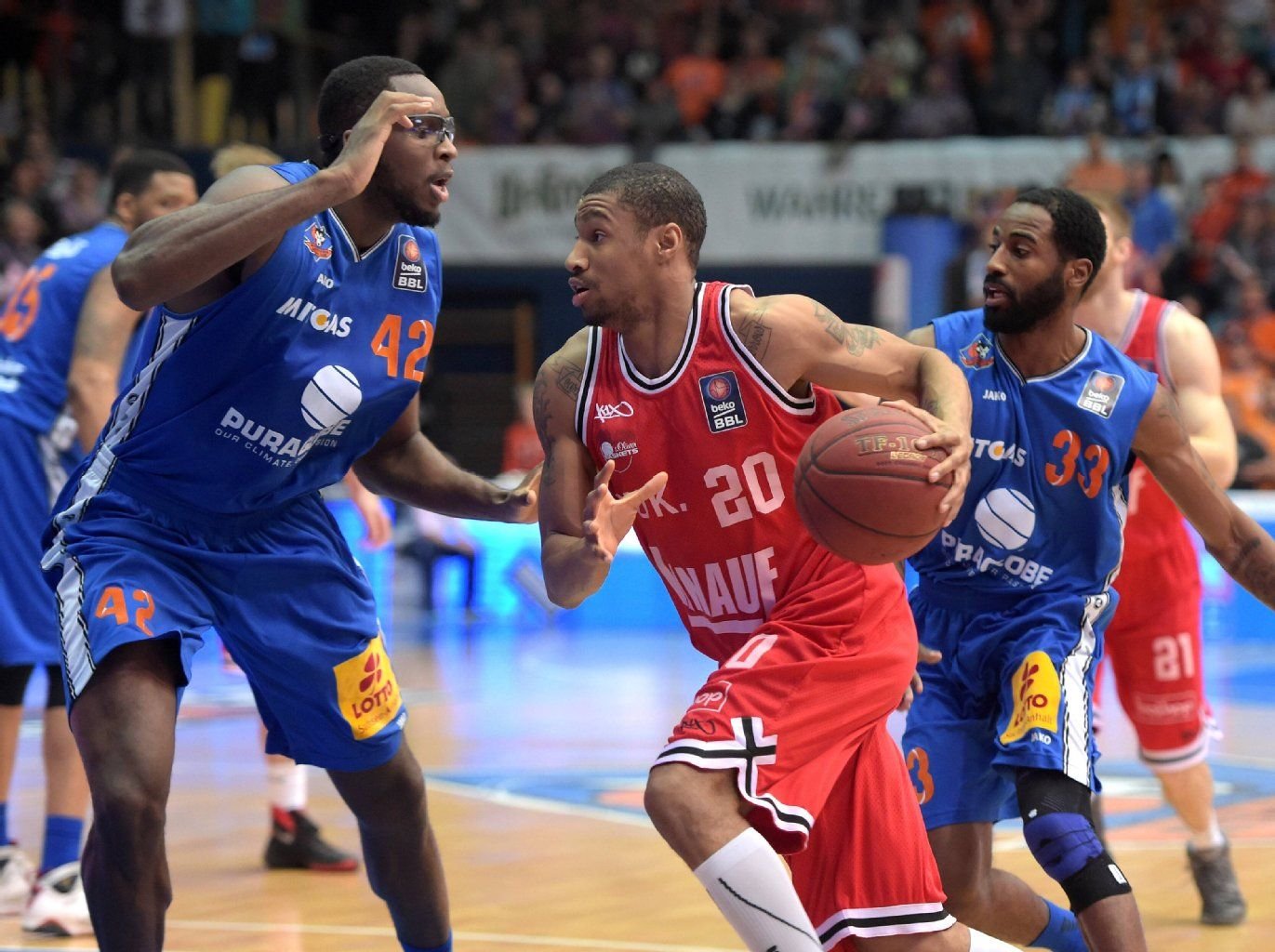 Würzburgs Cameron Long (M.) gegen Chris Otule (l.) und Marcus Hatten im Spiel Mitteldeutscher BC gegen s.Oliver Baskets Wuerzburg.