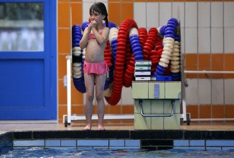 Ein Mädchen steht m Becken der Schwimmhalle. (FOTO: DPA)
