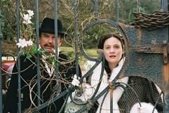 Im neuen Kinofilm «Angel - Ein Leben wie im Traum» stehen Theo (Sam Neill) und Angel (Romola Garai) hinter einem verschlossenen Tor. (Foto: dpa)