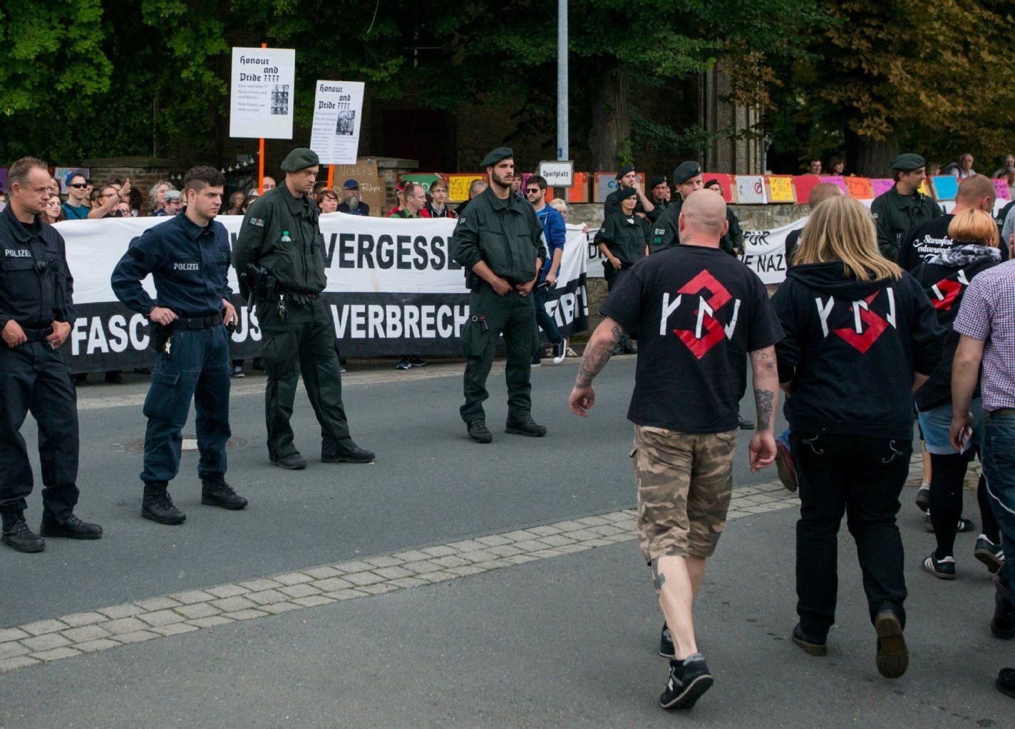 Besucher eines Konzertes mit rechter Musik laufen am 28.06.2014 im Schwanebecker Ortsteil Nienhagen (Sachsen-Anhalt) an Polizisten und etwa 200 Gegendemonstranten vorbei.