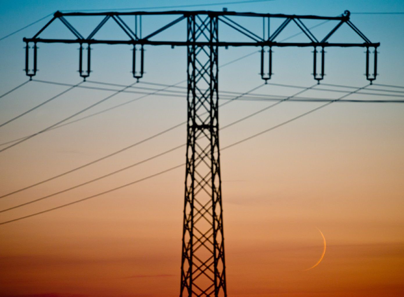 Ein Strommast ist vor dem Abendhimmel zu sehen. Ziel des Volksbegehrens ist es, dass Berlin sein Stromnetz zurückkauft und mit eigenen Stadtwerken ausschließlich Ökostrom produziert.