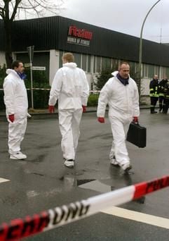 Drei Männer der Spurensicherung stehen am Mittwoch (29.01.2003) vor einem Fitness-Studio im westfälischen Telgte, auf dessen Parkplatz in der Nacht auf drei Frauen geschossen wurden war. Zwei 30 und 39 Jahre alten Frauen waren sofort tot. Das dritte, 34 Jahre alte Opfer, starb im Krankenhaus. Ein Passant hatte gegen 2.00 Uhr in der Nacht die drei leblosen Körper entdeckt und die Polizei alarmiert. (Foto: dpa)