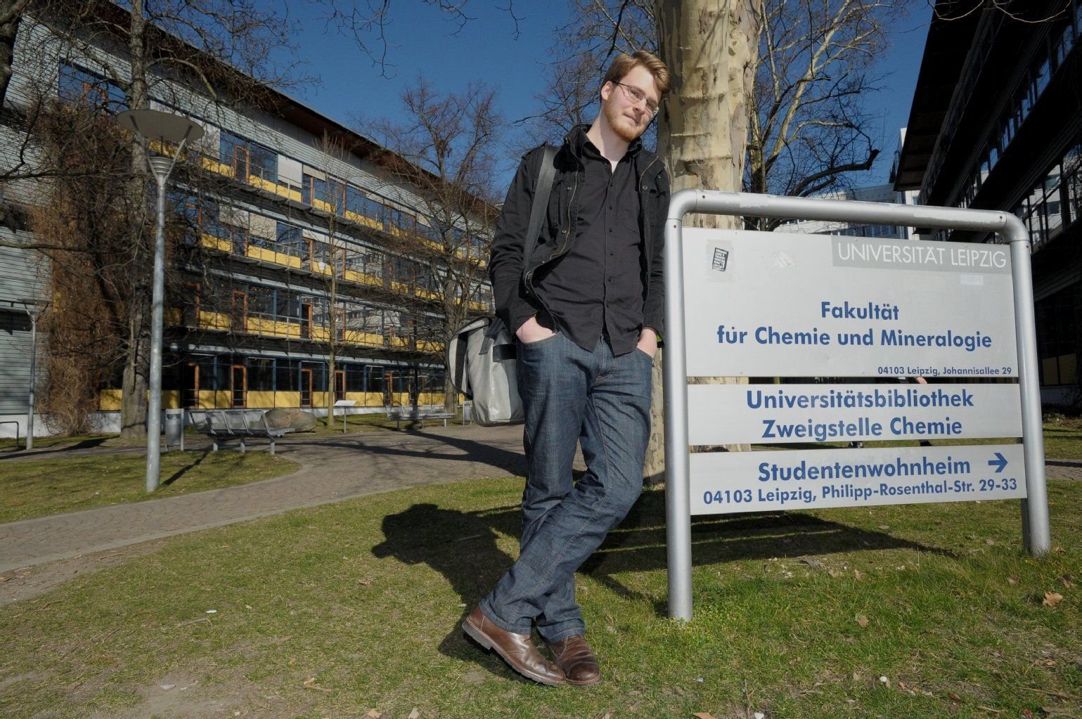 David Langer, Student im 5. Semester (Bachelor), steht am Eingangsschild des Institutes für Chemie und Mineralogie der Universität Leipzig in Leipzig .
