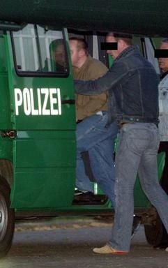 In einen Polizeiwagen steigt Markus Wirtz (l) auf einem kleinen Flugplatz bei Aachen. (Foto: dpa)