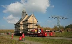 Der Schwertransport mit der Heuersdorfer Emmaus-Kirche rollt auf der Straße von Deutzen nach Neukiritzsch (Landkreis Leipziger Land). (Foto: dpa)