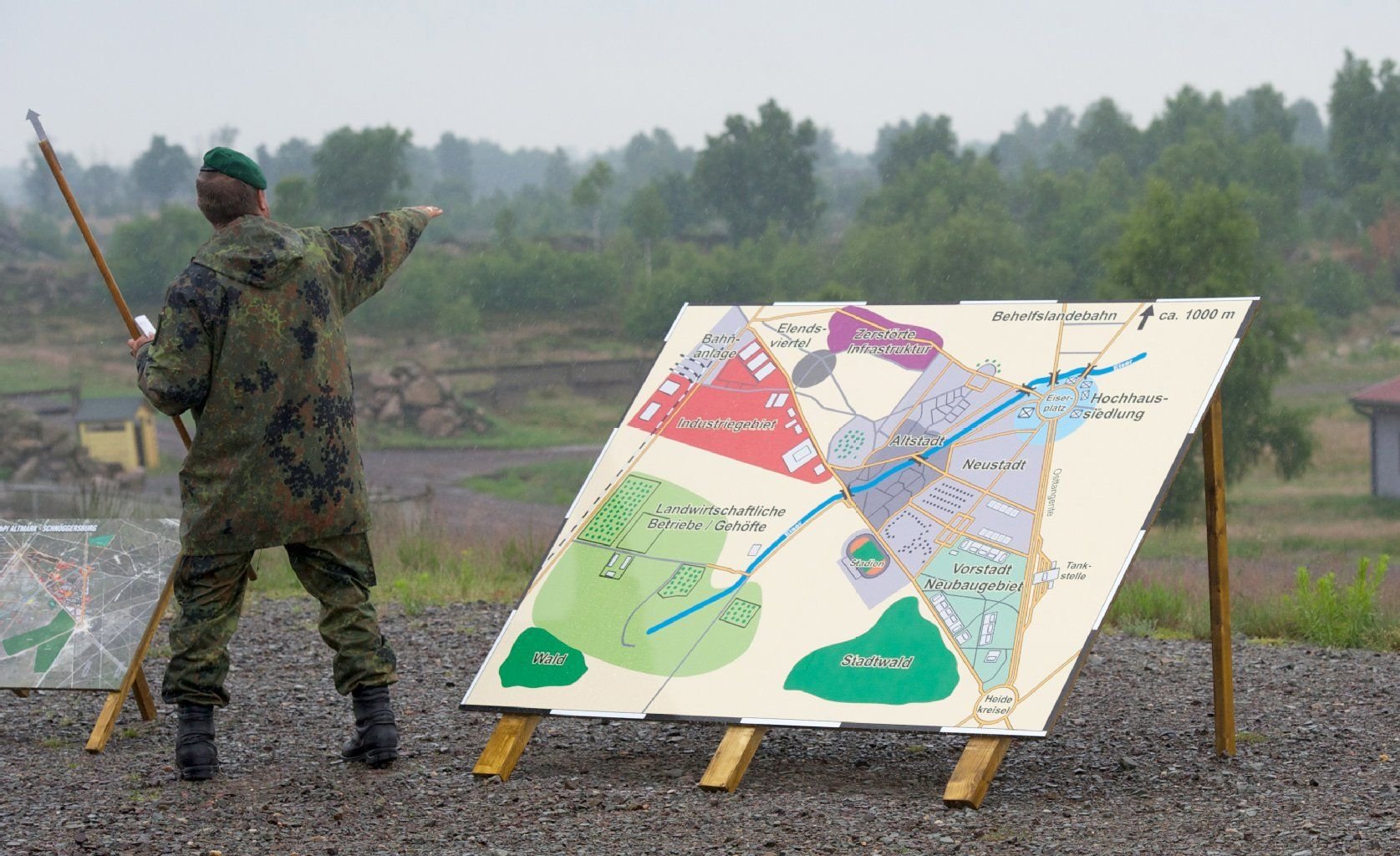 Ein Soldat zeigt auf dem Truppenübungsplatz Altmark in Letzlingen (Altmarkkreis Salzwedel) auf eine entstehende Übungssiedlung.