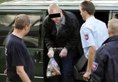 Der wegen Mordes an seinen Großeltern angeklagte 15-Jährige wird am Mittwoch (15. September 2004) am Hintereingang des Landgerichtes in Hildesheim beim Aussteigen aus einem Kleinbus von Justizbeamten in Empfang genommen. (Foto: dpa)