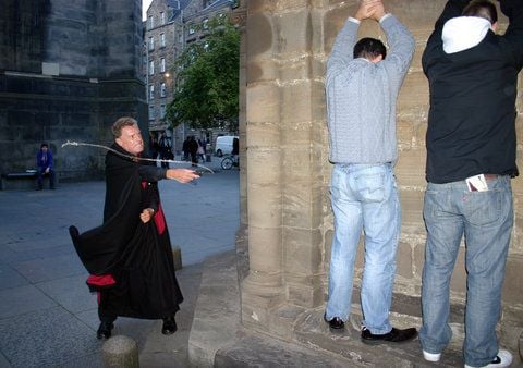 Gespenster-Guide William demonstriert an zwei Touristen, wie in Edinburgh im Mittelalter Übeltäter gezüchtigt wurden. (FOTO: CHRISTOPH DRIESSEN)